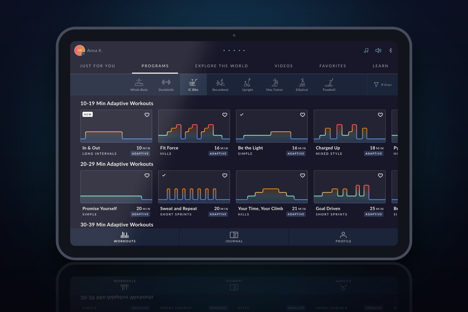 JRNY Programs tab on a tablet showing rows of adaptive workout cards with colored brickyard intensity graphs.